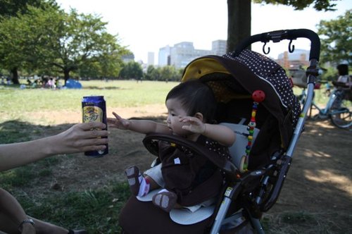 木場公園でビールに手を伸ばす